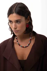 Collar corto compuesto por cuentas de amazonita, ágata tibetana y acrílico en tonos rojos, negros, blancos y celestes. Cuenta con cadena de acero quirúrgico para ajuste de largo.