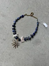 Collar de piedras naturales en tonos verdes con dije colgante de bronce con diseño orgánico.