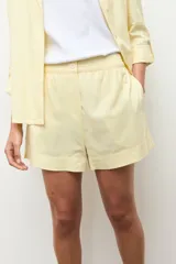 Short de lino color marrón topo, con cintura elástica y botón frontal.