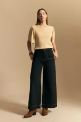 Remera de rib color beige, con cuello redondo y mangas cortas amplias con leve frunce en los hombros. Confeccionada en tejido elastizado de textura acanalada.