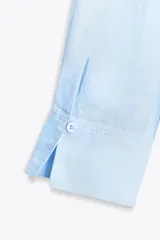 Camisa color coral confeccionada en lino 100%, de corte recto, con cuello solapa, manga larga con puños abotonados y cierre frontal con botones.