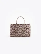 Bandolera de cuero vacuno con estampado de labios, manijas de mano y correa ajustable para llevar al hombro o cruzada. Cuenta con un bolsillo frontal con cierre y un llavero colgante con dije de corazón.