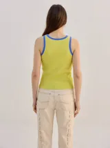 Musculosa básica Mutma Nifa de algodón color negro, con diseño ajustado al cuerpo, ribetes blancos en contraste en el cuello y sisas, y logo bordado en el centro del pecho.