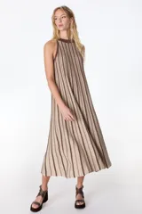 Vestido largo de tejido de punto con lurex, de silueta en A, sin mangas y cuello halter. Presenta un diseño de rayas verticales en tonos marrón y beige.