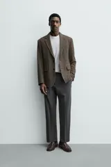Pantalón de vestir regular fit color negro, confeccionado en tejido con mezcla de lana y elasticidad. Cuenta con cintura elástica, bolsillos frontales, bolsillos traseros de vivo con botón, y cierre frontal con cremallera y botón.