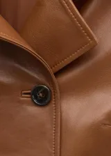 Chaqueta de cuero de ovino en color marrón, de diseño corto y cruzado, con doble botonadura frontal y solapas clásicas.