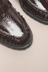 Mocasín Helen de cuero vacuno con acabado charol, color negro. Cuenta con un taco de 3,5 cm y suela de goma.