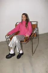 Pantalón plateado de cuerina, corte recto con tajo en el ruedo.