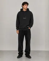 Canguro negro de corte holgado con capucha ajustable mediante cordones, bolsillo frontal tipo canguro y logo bordado en el pecho.