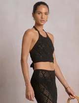 Top crop de tejido calado beige, con escote halter y patrón geométrico de rombos.