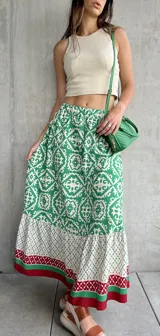Falda larga estampada con motivos geométricos en verde, blanco y rojo.