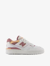 Championes urbanos New Balance modelo 550, color blanco con detalles en rosa y amarillo, confeccionados en cuero sintético, con logo "N" característico en los laterales.