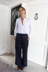 Pantalón de corte sastrero con pierna recta, confeccionado en gabardina con tencel. Presenta un diseño de color azul marino con detalle de rayas laterales en contraste.
