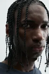 Camiseta relaxed fit color azul marino, con cuello redondo y manga corta. Presenta un estampado combinado a contraste en el delantero y la espalda. El estampado frontal es un texto en cursiva y un dibujo de tres figuras alargadas.