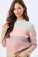 Buzo tejido de punto con diseño de rayas horizontales en tonos gris, rosa, malva y beige. Presenta cuello redondo, mangas largas y puños acanalados, con una pequeña etiqueta de cuero sintético en el ruedo.