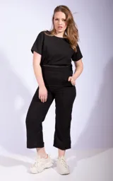 Mono negro de dos piezas, compuesto por una remera de mangas cortas y un pantalón capri de tiro alto.