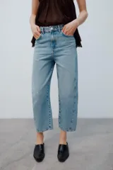 Jeans de tiro medio con diseño de volumen crop, confeccionados en denim de lavado azul clásico, con cinco bolsillos y costuras decorativas laterales.