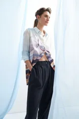Pantalón de vestir azul marino, de corte recto, con bolsillos laterales y traseros. Se ajusta a la cintura con cinturón de cuero marrón.