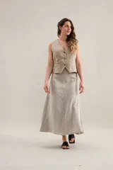 Falda larga de lino color beige, con diseño de cortes diagonales y silueta acampanada.