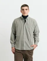 Camisa de franela lisa con cuello button-down, manga larga, bolsillo frontal y botones al tono.