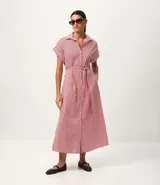 Vestido largo estilo chemise con estampado de rayas rojas y blancas, cuello clásico, cierre frontal con botones y mangas cortas amplias. Incluye un cinto desmontable para ajustar en la cintura.