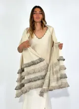 Chal de punto color beige con textura calada y volados en los bordes.