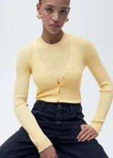 Cardigan de punto acanalado color amarillo, con escote en V, cierre frontal con botones y mangas largas.