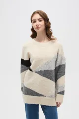 Sweater de tejido de punto con diseño geométrico color block en tonos beige, gris y negro, de corte holgado, cuello redondo y manga larga.