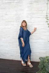 Vestido largo azul marino con escote en V, mangas anchas y textura plisada. Presenta capas de flecos que caen desde el pecho hasta el ruedo.