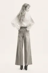 Pantalón jean de denim de algodón con leve stretch, tiro alto y pierna ancha. Cuenta con bolsillos tipo parche en el frente y raya marcada en ambas piernas.