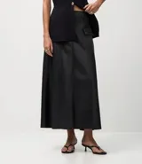 Pollera midi de corte evasé confeccionada en cuero sintético (PU), con cintura elástica, trabillas para cinturón y solapas decorativas en la parte delantera.