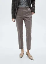 Pantalón de vestir marrón de tiro medio, con diseño crop y corte skinny, trabillas para cinto, bolsillos laterales y cierre oculto con botón, gancho y cremallera.