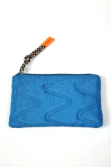 Billetera rectangular de color azul, con diseño acolchado de costuras en zigzag y cierre superior con tirador de cordón trenzado multicolor con punteras naranjas.