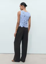 Top sin mangas de tejido crochet con diseño floral calado, cuello redondo y terminaciones festoneadas.