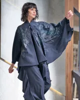 Capa de gabardina de lana estampada con diseño exclusivo "humanprint" en color metal azulado, con corte asimétrico.