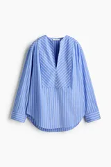 Camisa de algodón con diseño a rayas azules y blancas, corte oversized, escote en V profundo y mangas largas con hombros caídos y puños anchos.