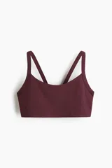 Top deportivo color bordó de tejido funcional, con escote redondo y breteles dobles en la espalda. Cuenta con elástico revestido en el bajo y copas con relleno extraíble.