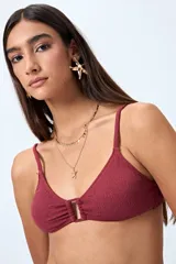 Top de bikini azul con textura fruncida y detalle de aro al frente. Posee breteles finos regulables y un calce cómodo que realza el busto con un toque moderno.