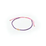 Pulsera ajustable con mostacillas lilas y doradas, y cordón rosa.