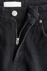 Jean de tiro alto y pierna ancha color negro, confeccionado en denim de algodón con diseño clásico de cinco bolsillos.