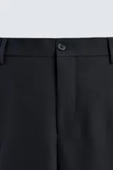 Pantalón de corte recto confeccionado en tejido con lana, color beige. Presenta bolsillos frontales, bolsillos traseros de vivo y cierre frontal con cremallera y botón.