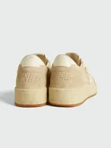 Zapatillas deportivas Golden Goose modelo Ball Star, color beige claro, con estrella lateral en color crema y suela de goma color caramelo. Presentan un aspecto desgastado intencional y texto grabado en el lateral.