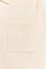 Jersey de punto con cuello tipo polo, manga larga con puños y cierre frontal con botones. Presenta un bolsillo de plastrón en el pecho y diseño de corte holgado.
