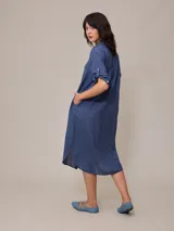 Vestido camisero largo de lino y algodón, color azul, con cuello camisero y botones frontales.