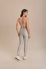 Top deportivo negro con tirantes finos cruzados en la espalda y relleno extraíble. Fabricado en tejido Allure® con tecnología LYCRA® ADAPTIV, ofrece elasticidad, adaptándose al cuerpo y realzando la figura.