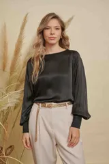 Blusa de satén color champagne con cuello a la base, mangas anchas y puños elásticos con detalle bordado.