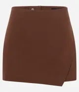 Short pollera de bengalina color marrón, con diseño de recorte delantero tipo cruzado y cierre invisible en la parte posterior.