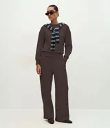 Pantalón Marfinno de corte wide leg, confeccionado en tejido de moletón color marrón. Presenta cintura elástica, diseño liso con costuras verticales decorativas y una caída fluida.