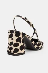 Zapato destalonado de piel con pelo, con estampado animal print. Presenta tacón alto ancho, tira trasera ajustable con hebilla metálica y acabado en punta cuadrada.