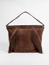 Cartera tipo hobo color rojo, confeccionada en gamuza, con flecos laterales, tachas metálicas decorativas y asa de hombro.